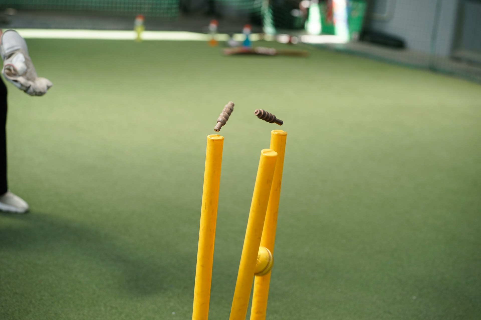 A man standing next to a yellow bat and ball